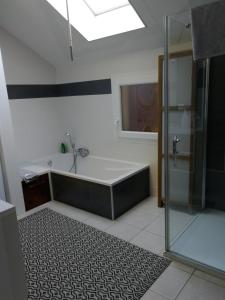 een badkamer met een bad en een douche bij Maison de ville au calme in Bonneville