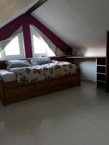 een bed in een kamer met 2 ramen bij Maison de ville au calme in Bonneville