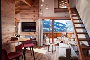 Zimmer mit einer Treppe und einem Wohnzimmer mit Aussicht in der Unterkunft Der Böglerhof - pure nature spa resort in Alpbach