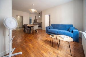 a living room with a blue couch and a table at Appartement centre-ville 6 personnes in Chalon-sur-Saône +3 photos