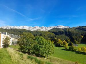 a view of the mountains with trees and a building at les glovettes Villard de lans in Villard-de-Lans