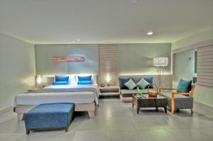 a bedroom with a large bed with blue pillows at ASHLEE Heights Hotel Patong in Patong Beach