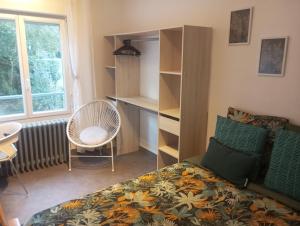 um quarto com uma cama, uma cadeira e uma janela em Appartement hyper centre lorient Jardin clos em Lorient