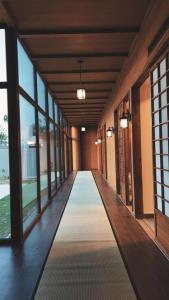 un couloir d'un bâtiment avec des fenêtres et un long couloir dans l'établissement THE JAPANESE HOUSE by BRIDGE RETREATS, à Ras al Khaimah