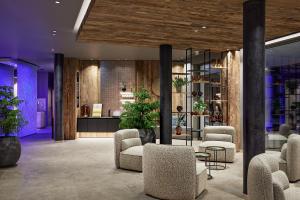 a lobby with chairs and plants in a building at Der Böglerhof - pure nature spa resort in Alpbach