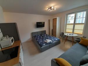 um pequeno quarto com uma cama e uma televisão em Welcome Cozy Apartment Old Town em Elblag
