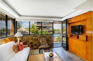 sala de estar con sofá, TV y ventanas en Vientos del Caribe Club & Hotel en El Yaque