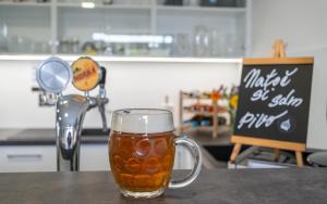 a glass of beer sitting on a table at Vincent in Luhačovice