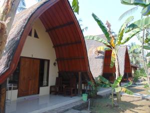 a view of a house with a thatched roof at Ings Garden in Gili Air