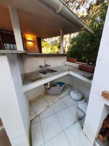 a dirty bathroom with a sink and two toilets at Große Wohnung mitten im Park in Punta del Este
