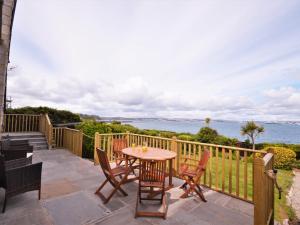 a patio with a table and chairs and the ocean at 3 Bed in Brixham BX007 in Brixham