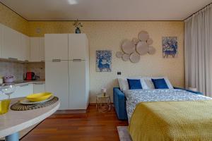 a bedroom with a blue bed and a kitchen at Porta Romana Suite di Charme in Milan