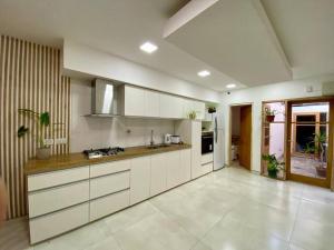 cocina grande con armarios y electrodomésticos blancos en Casa Moro Valle de Uco-Tupungato-Mendoza, en Tupungato
