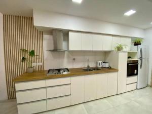 Una cocina con gabinetes blancos y un refrigerador blanco. en Casa Moro Valle de Uco-Tupungato-Mendoza, en Tupungato