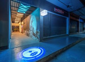 a neon sign on the side of a building at Space Station Hostel in Ban Don Muang