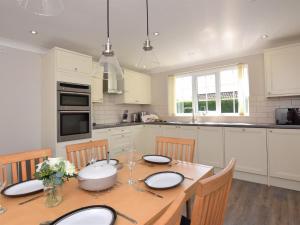 uma cozinha com uma mesa de madeira com cadeiras e uma sala de jantar em 3 Bed in Fakenham 56661 em Whissonsett
