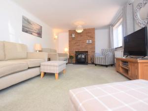 uma sala de estar com um sofá e uma televisão de ecrã plano em 3 Bed in Fakenham 56661 em Whissonsett