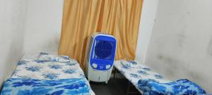 a room with two beds and a blue and white heater at Mannat Rooms in Allahābād