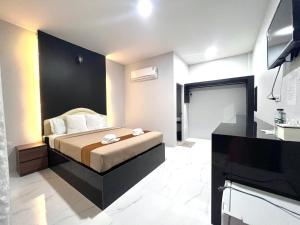 una camera d'albergo con un letto e un bagno di BM Beach Resort Satun บีเอ็มบีชรีสอร์ท a Ban Pak Ba Ra Altre 16 foto