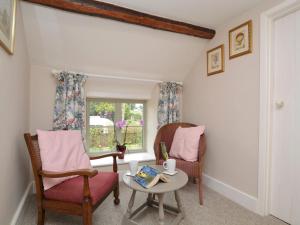 a living room with two chairs and a table and a window at 3 Bed in Bridport 57688 in Mosterton