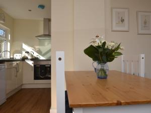 a vase of flowers sitting on a wooden table in a kitchen at 2 Bed in Weston-super-Mare 57144 in Weston-super-Mare