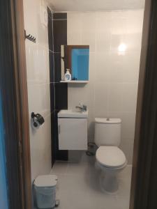 a white bathroom with a toilet and a mirror at LAVİNYA PENSİON in Kuşadası