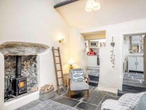 sala de estar con chimenea de piedra y silla en 2 Bed in Llwyngwril 58564, en Llwyngwril