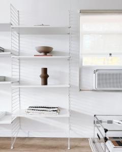 eine weiße Küche mit weißen Regalen und einer Mikrowelle in der Unterkunft Luxury Poconos Home Near Skiing, Lakes, & Waterparks in Tobyhanna