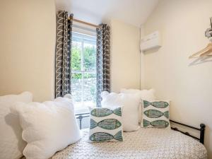 1 dormitorio con cama con almohadas y ventana en 2 Bed in Llwyngwril 58564, en Llwyngwril