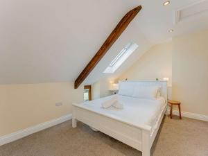 een slaapkamer met een wit bed en een dakraam bij 5 Bed in Aberystwyth 58889 in Llanrhystyd