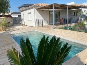 a swimming pool in front of a house at Une parenthèse face aux vignes in Sorgues