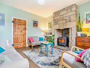 a living room with a stone fireplace and a couch at 3 Bed in Bamburgh CN022 in Smeafield