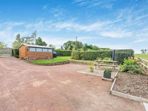 a backyard with a wooden shed and a picnic table at 3 Bed in Bamburgh CN022 in Smeafield