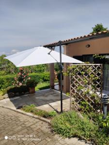 un paraguas blanco delante de una casa en Un Giardino sul Lago, en Montefiascone