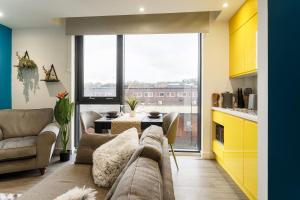 a living room with a couch and a large window at Brand New Studio Apartment in Sheffield in Sheffield