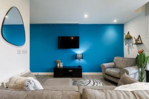 sala de estar con sofá y pared azul en Brand New Studio Apartment in Sheffield, en Sheffield