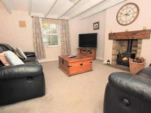 a living room with couches and a tv and a fireplace at 2 Bed in Nr Amble CN049 in Acklington