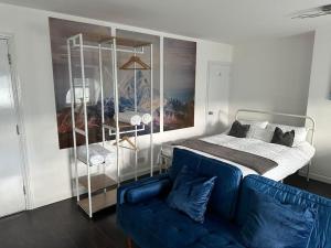 een slaapkamer met een bed en een blauwe bank bij Dartford Town 3 Bed by Harlington in Kent