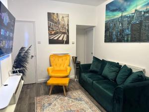 a living room with a green couch and a yellow chair at Dartford Town 3 Bed by Harlington in Kent
