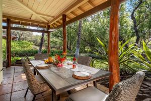 a table and chairs on a screened porch with a table and chairs at Mauna Lani Fairways 302 in Waikoloa
