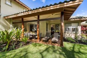 a patio with a pergola and a table and chairs at Mauna Lani Fairways 302 in Waikoloa