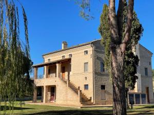 una vecchia casa in pietra con scale laterali di Monterosato Country House a Fermo