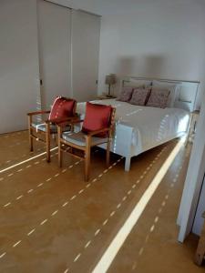 a bedroom with a bed with two chairs and a table at Quinta do Pinhô - The Poolhouse in Salzedas