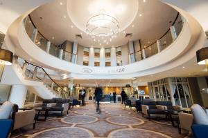 a lobby of a building with chairs and a staircase at Crowne Plaza - Belfast by IHG in Belfast