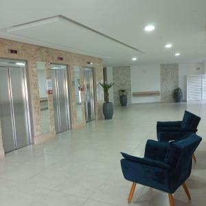 un vestíbulo con 2 sillas azules en un edificio en Estúdio Mobiliado Condomínio da Fé Canção Nova apto 02, en Cachoeira Paulista