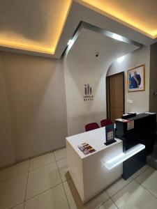 an office with a reception desk and two red chairs at Ixoras Hotel Victoire in Kinshasa