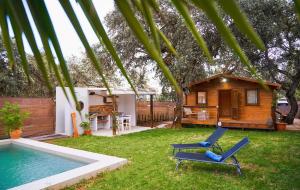 podwórze z basenem, dwoma krzesłami i domem w obiekcie Cabaña Rural El Arbol near Setenil - Ronda con piscina w mieście Ronda