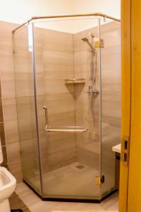 a shower with a glass door in a bathroom at At Freddy's with free transport from JKIA in Nairobi