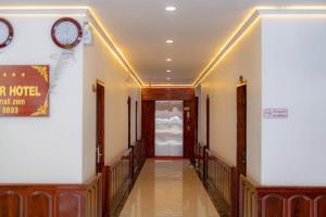 a hallway in a hotel with a clock on the wall at LuangPrabang Center Hotel in Luang Prabang