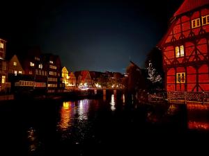 una città di notte con un fiume e edifici di Gemütliche Ferienwohnung in Uelzen mit eigenem Garten a Uelzen